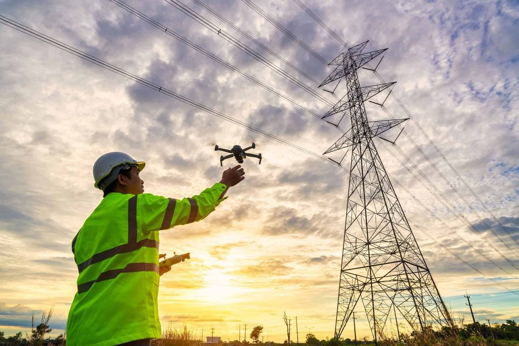 technician launching drone for power line maintenance inspection